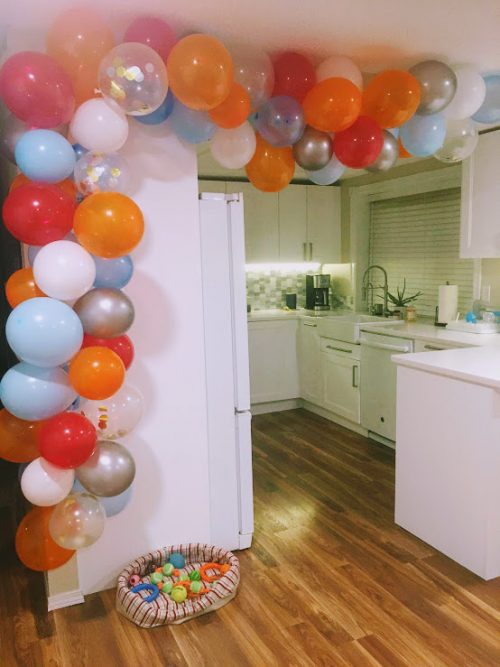 DIY balloon garland first birthday party ideas on a budget